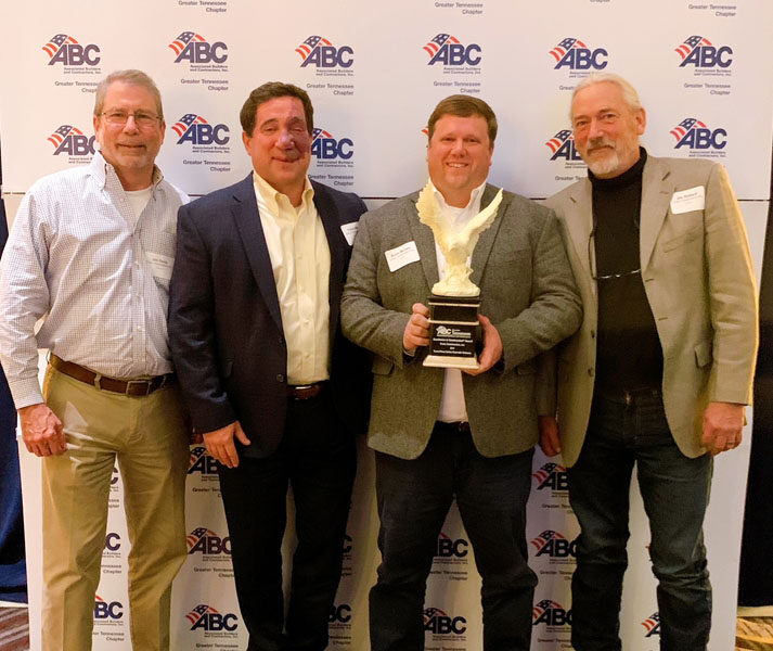 Crain leaders holding Eagle Award trophy