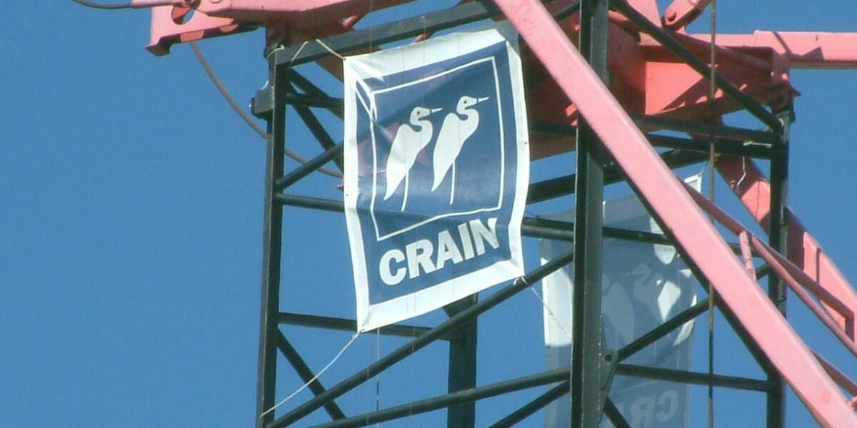 Crain Construction banner waving in the wind off scaffolding in the sky