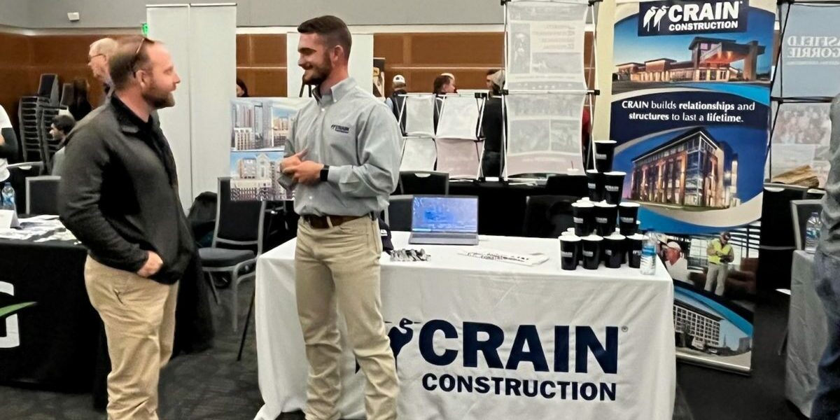 Spencer Rankin is standing in front of the Crain Construction booth at the MTSU Career Fair