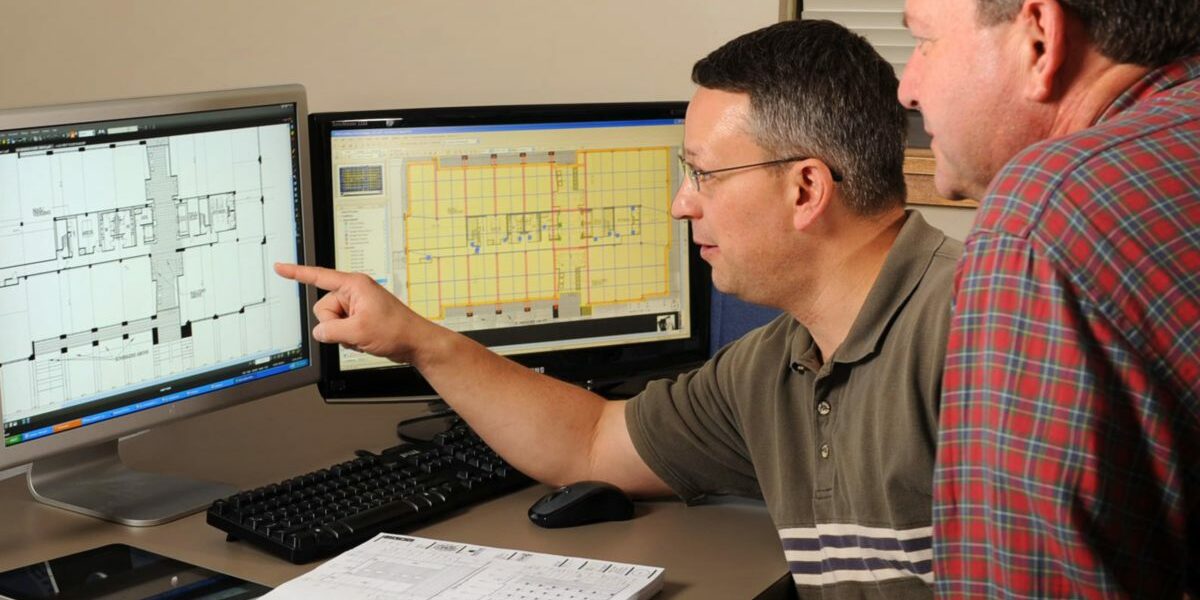 two male workers looking over plans and discussing Pre-construction questions