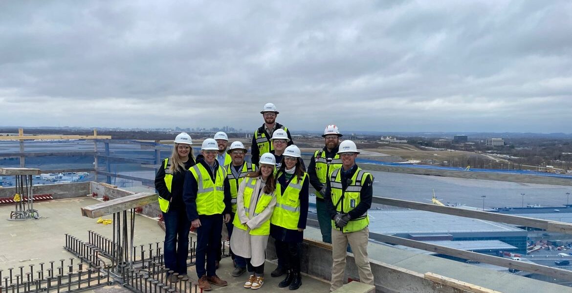 the Crain Construction team on the rooftop of the BNA Hilton with hardhats on a cloudy day