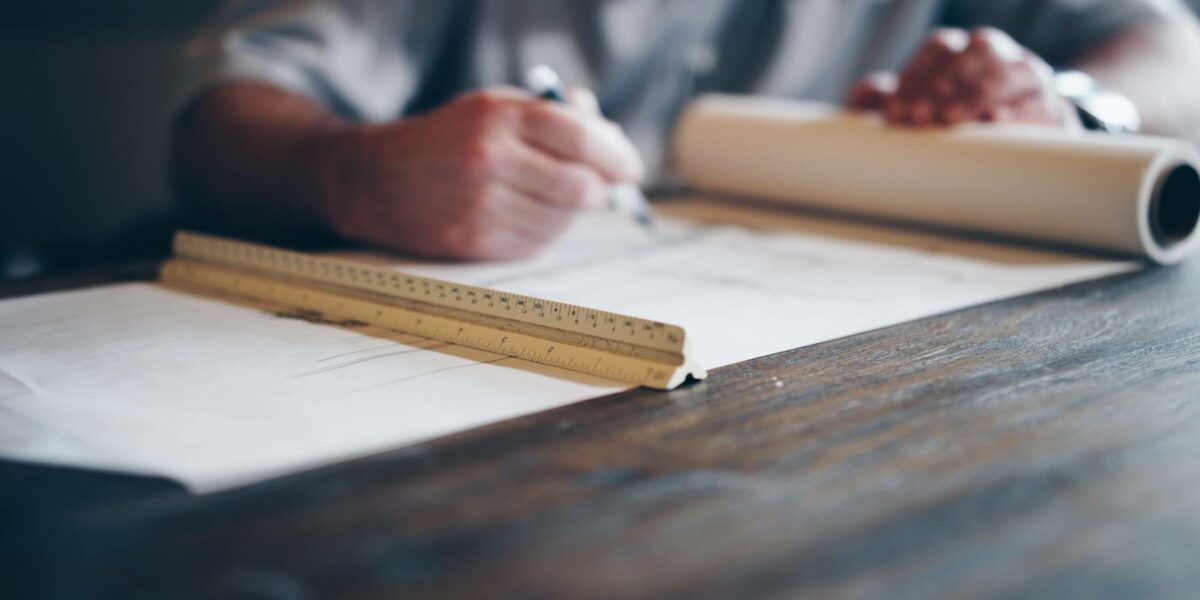 man looking at construction plans on a wood table