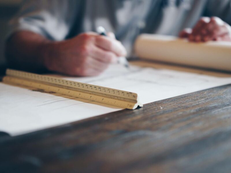 man looking at construction plans on a wood table