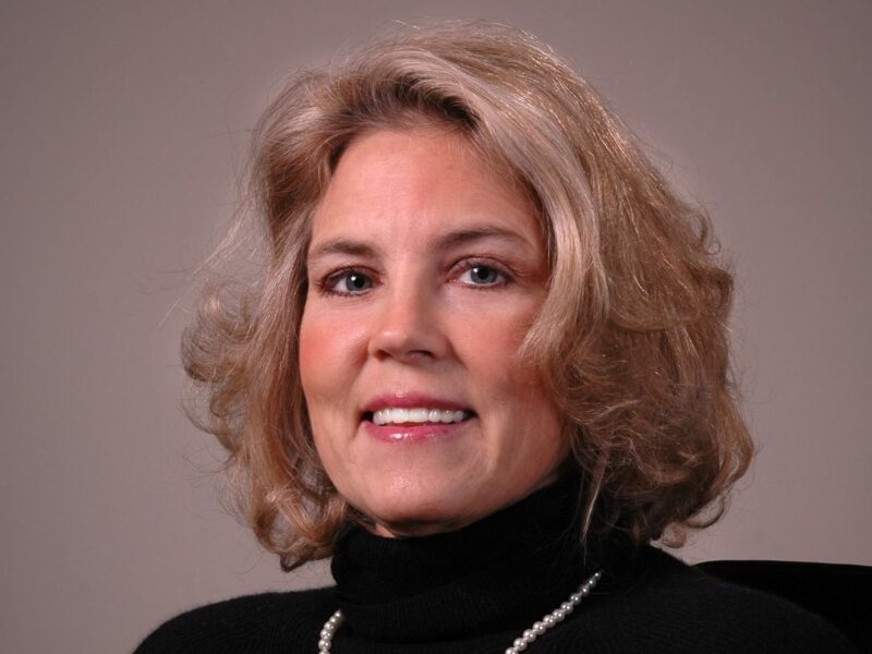 Portrait of Sherry Arledge, wearing professional attire, with a friendly smile, in a well-lit indoor setting.