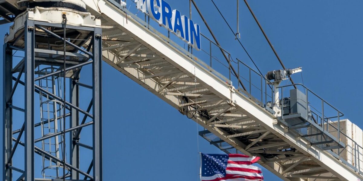 American flag hanging from a Crain Construction crain.