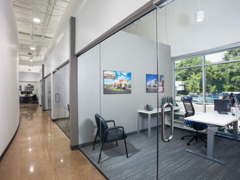 Inside of the Crain Construction Office, featuring all-glass doors and exposed ceilings.