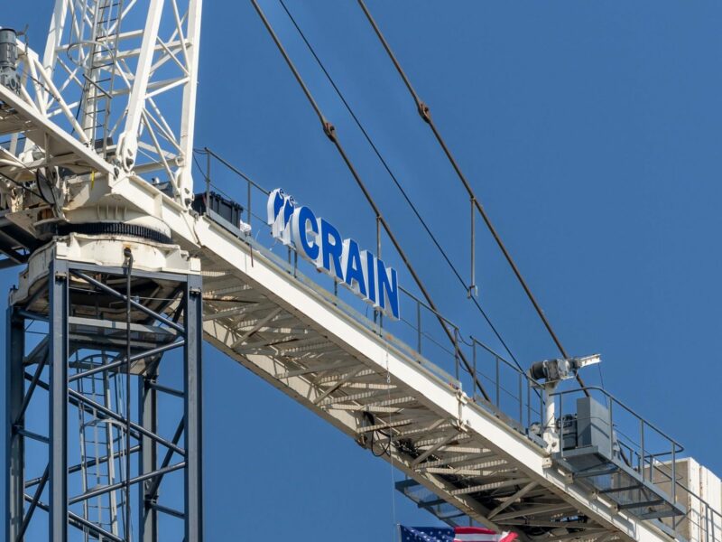 American flag hanging from a Crain Construction crain.