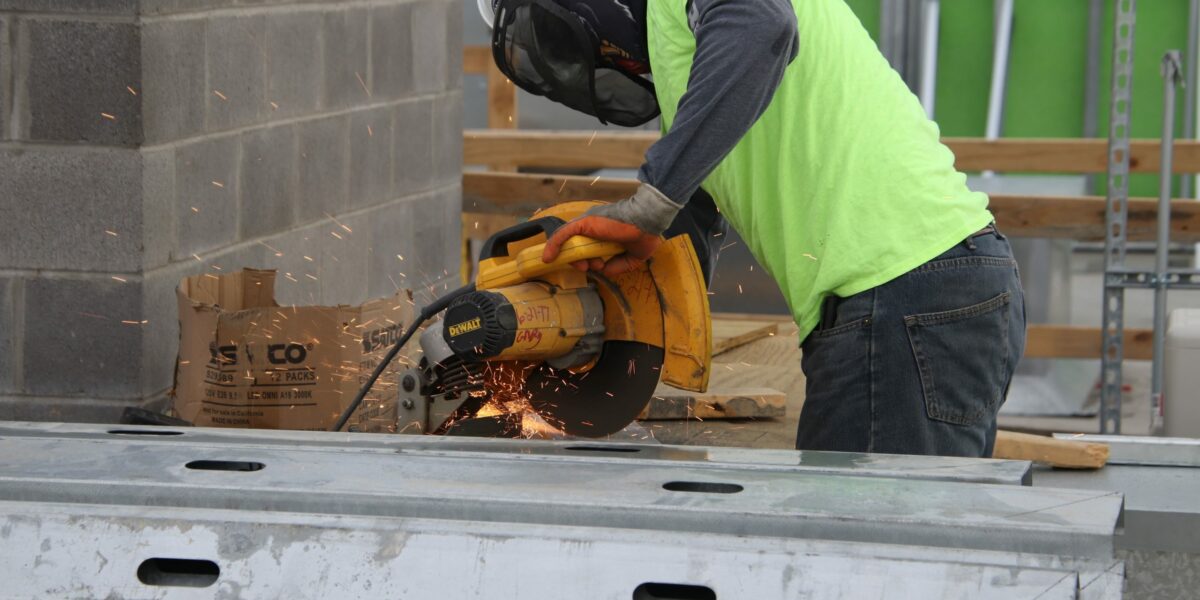 construction worker in safety gear using a table saw