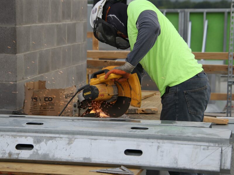 construction worker in safety gear using a table saw